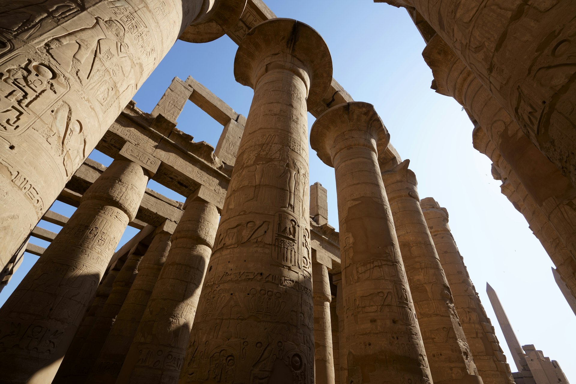 a group of pillars in a building with a sky background