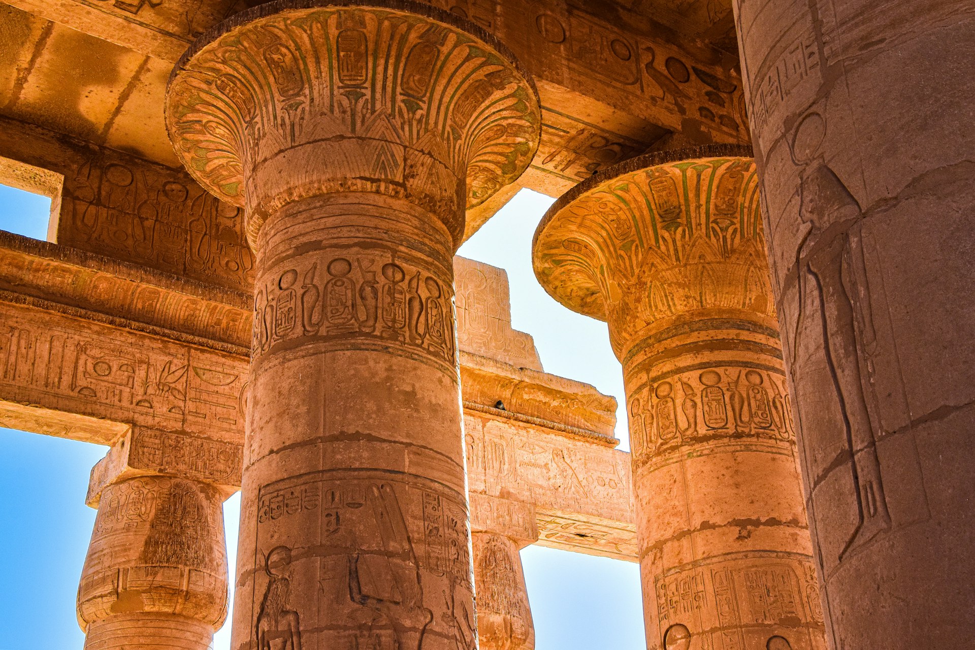 a group of pillars in a building with sky in the background